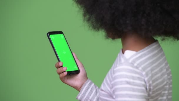 Νέοι χαριτωμένο Αφρικανική κορίτσι με Άφρο μαλλιά χρησιμοποιώντας το τηλέφωνό — Αρχείο Βίντεο