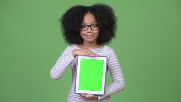 Ung Söt afrikansk flicka med Afro hår visar digitala tablett till kamera — Stockvideo