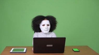 Genç Sevimli Afrikalı kız Afro saçlı dizüstü kullanarak hacker olarak