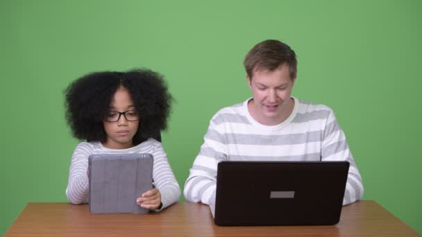 Joven chica africana y joven hombre escandinavo utilizando gadgets juntos — Vídeos de Stock