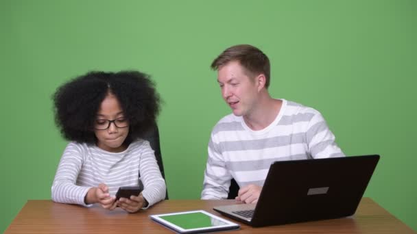 Young African girl and young Scandinavian man using gadgets together — Stock Video