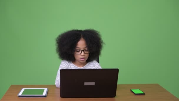 Young cute African girl with Afro hair using laptop — Stock Video