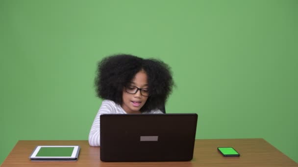 Young cute African girl with Afro hair using laptop — Stock Video