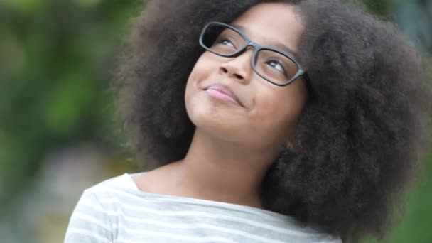 Unga glada afrikansk flicka med Afro hår tänkande på gatorna utomhus — Stockvideo