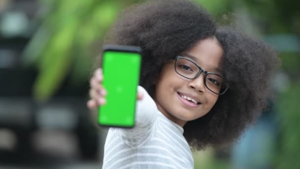 Jeune fille africaine mignonne avec des cheveux afro montrant téléphone dans les rues à l'extérieur — Video