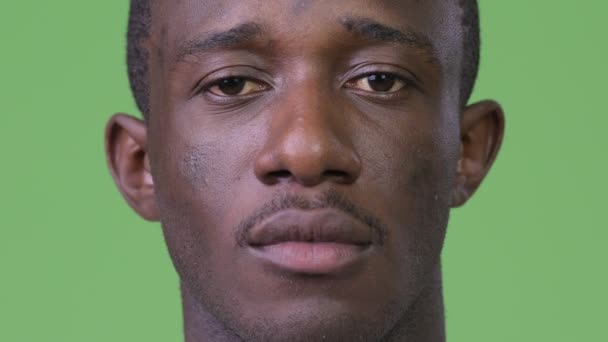 Yeşil arka plana karşı genç Afrika adam kafa vurdu — Stok video