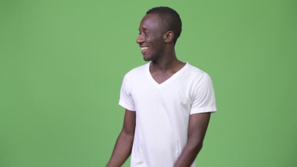 Молодой африканский мужчина улыбается, показывая что-то — стоковое видео