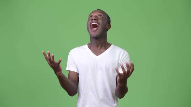 Junger glücklicher afrikanischer Mann lächelt, während er etwas fängt — Stockvideo