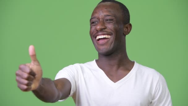 Joven hombre africano feliz sonriendo mientras da pulgares hacia arriba — Vídeos de Stock