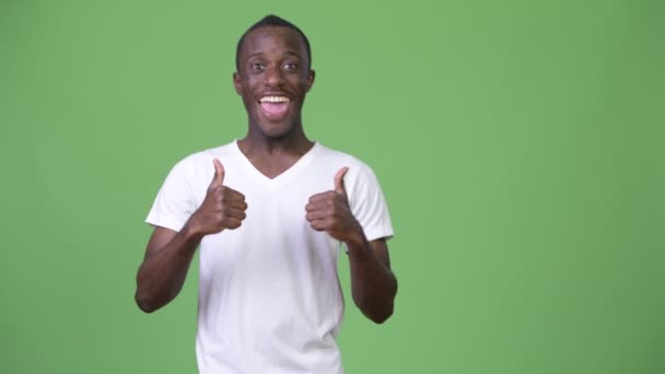 Молодой счастливый африканский мужчина улыбается, показывая большие пальцы вверх — стоковое видео