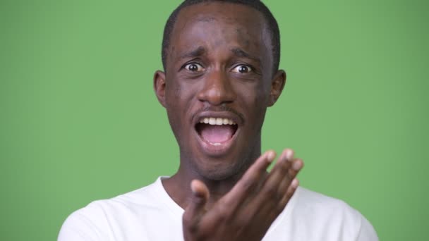 Young African man shocked while covering face — Stock Video