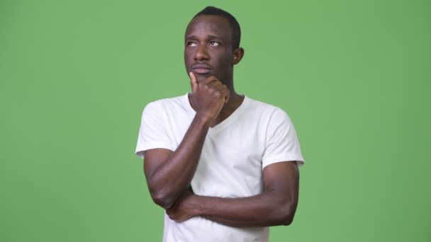 Young African man thinking against green background — Stock Video