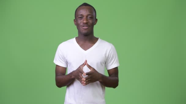 Junger Afrikaner spricht vor grünem Hintergrund — Stockvideo
