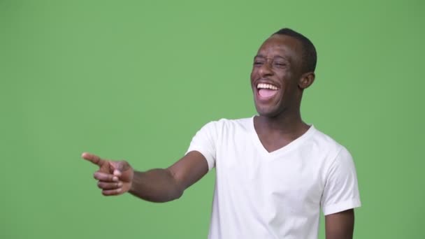 Joven hombre africano feliz riendo y señalando el dedo — Vídeo de stock