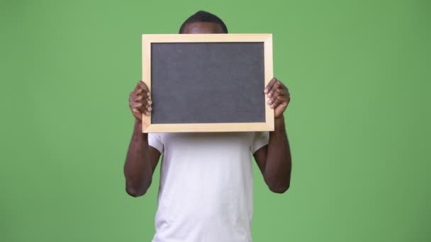 Young African man showing blackboard — Stock Video