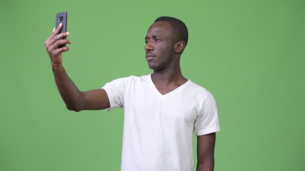 Mladí africké nabírající selfie před zeleným pozadím — Stock video