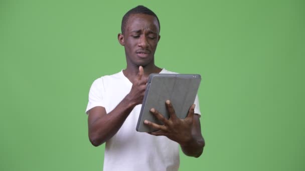 Szomorú afrikai fiatalember segítségével digitális tabletta — Stock videók