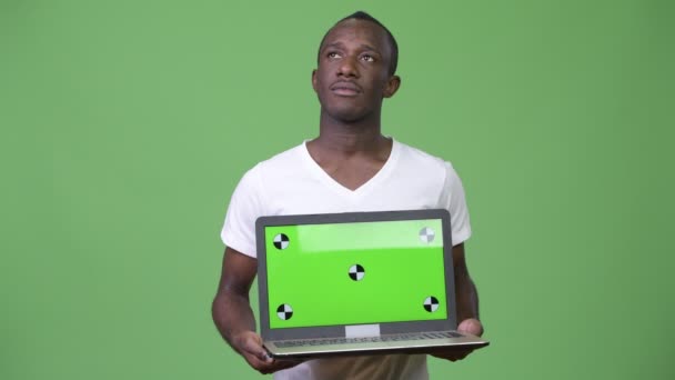 Молодой африканский человек думает, показывая ноутбук — стоковое видео