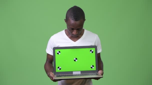 Ung afrikansk man visar laptop — Stockvideo