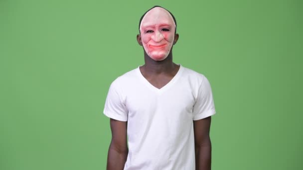 Jeune homme africain portant un masque et montrant le majeur — Video