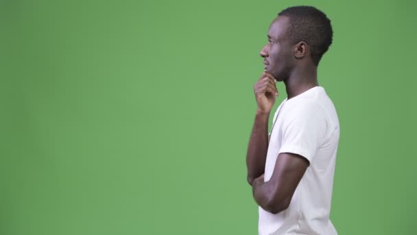 Profilbild eines jungen Afrikaners, der vor grünem Hintergrund denkt — Stockvideo