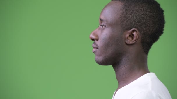 Widok profilu młody człowiek Afryki na zielonym tle — Wideo stockowe