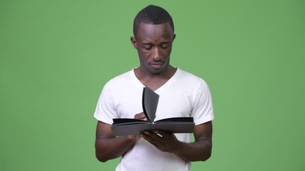 Молодой африканский человек читает книгу — стоковое видео
