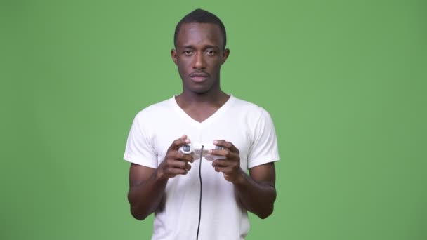 Joven africano mirando sorprendido mientras juega juegos — Vídeos de Stock