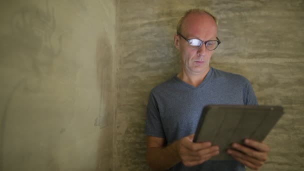 Mature Scandinavian man using digital tablet at home — Stock Video