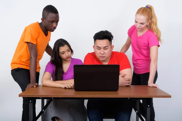 Photo studio d'un groupe diversifié d'amis multi-ethniques utilisant le lapto — Photo