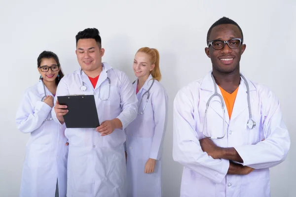 Studio shot of happy young African man doctor with arms crossed