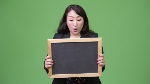 Reifen schöne asiatische Geschäftsfrau suchen schockiert, während zeigen Tafel — Stockvideo