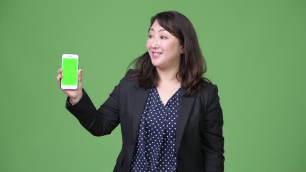 Mogen vackra asiatiska affärskvinna visar telefonen — Stockvideo