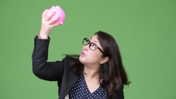 Reifen schön asiatische Geschäftsfrau halten Sparschwein — Stockvideo