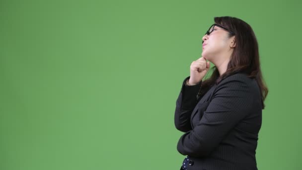 Perfil vista de madura hermosa mujer de negocios asiática pensando en fondo verde — Vídeos de Stock