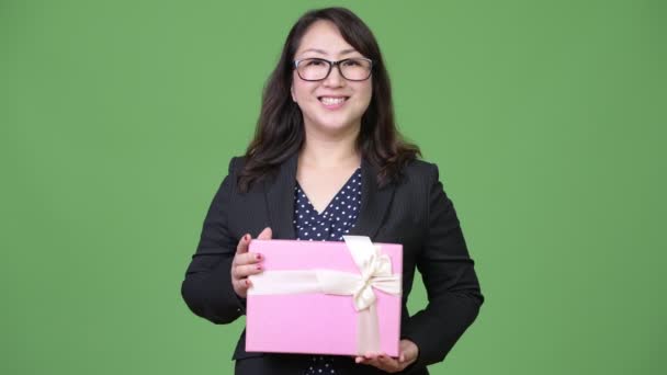 Зрелая красивая азиатская бизнесвумен с подарочной коробкой — стоковое видео
