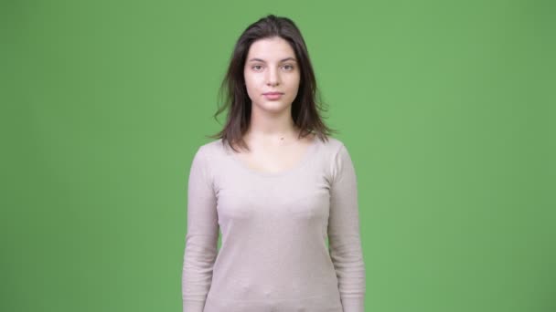 Junge schöne Frau vor grünem Hintergrund — Stockvideo