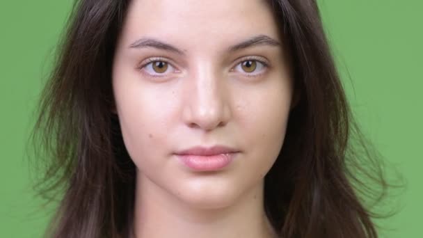 Ung vacker kvinna mot grön bakgrund — Stockvideo