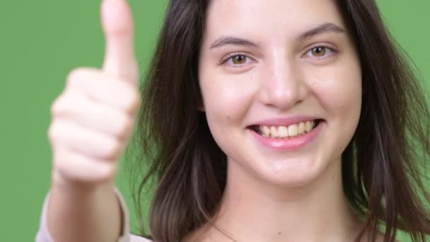 Young happy beautiful woman smiling while giving thumbs up — Stock Video