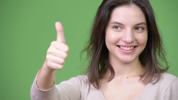 Молодая счастливая красивая женщина улыбается, показывая большие пальцы вверх — стоковое видео