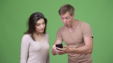 Telefonunuzun ve heyecanlı bakarken birlikte genç mutlu çift