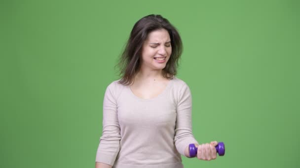 Молодая красивая женщина упражняется с гантелями — стоковое видео
