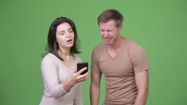Mladý pár, používání telefonu a scházení špatné zprávy — Stock video