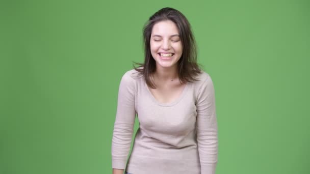 Gelukkig mooie jongedame lachen tegen groene achtergrond — Stockvideo