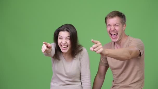 Молодая счастливая пара смеется и указывает пальцем друг на друга — стоковое видео