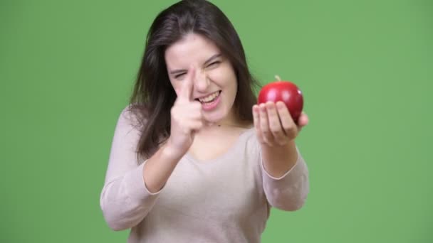 Joven hermosa mujer sosteniendo manzana y dando pulgares hacia arriba — Vídeo de stock