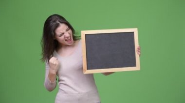 Blackboard tutarken heyecan arayan genç mutlu güzel kadın