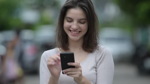 Ung glad vacker kvinna med telefon på gatorna utomhus — Stockvideo