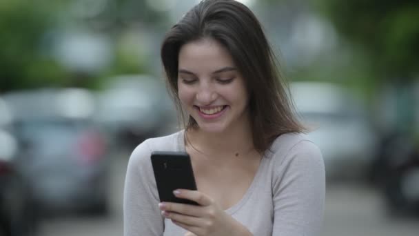 Mladá šťastná krásná žena pomocí telefonu v ulicích venku — Stock video