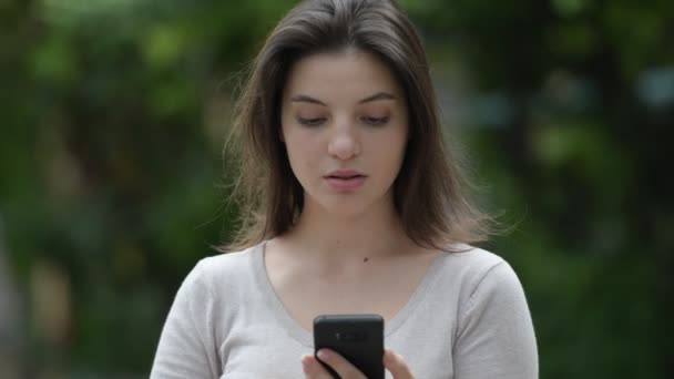 Jovem mulher bonita usando telefone e recebendo más notícias nas ruas ao ar livre — Vídeo de Stock